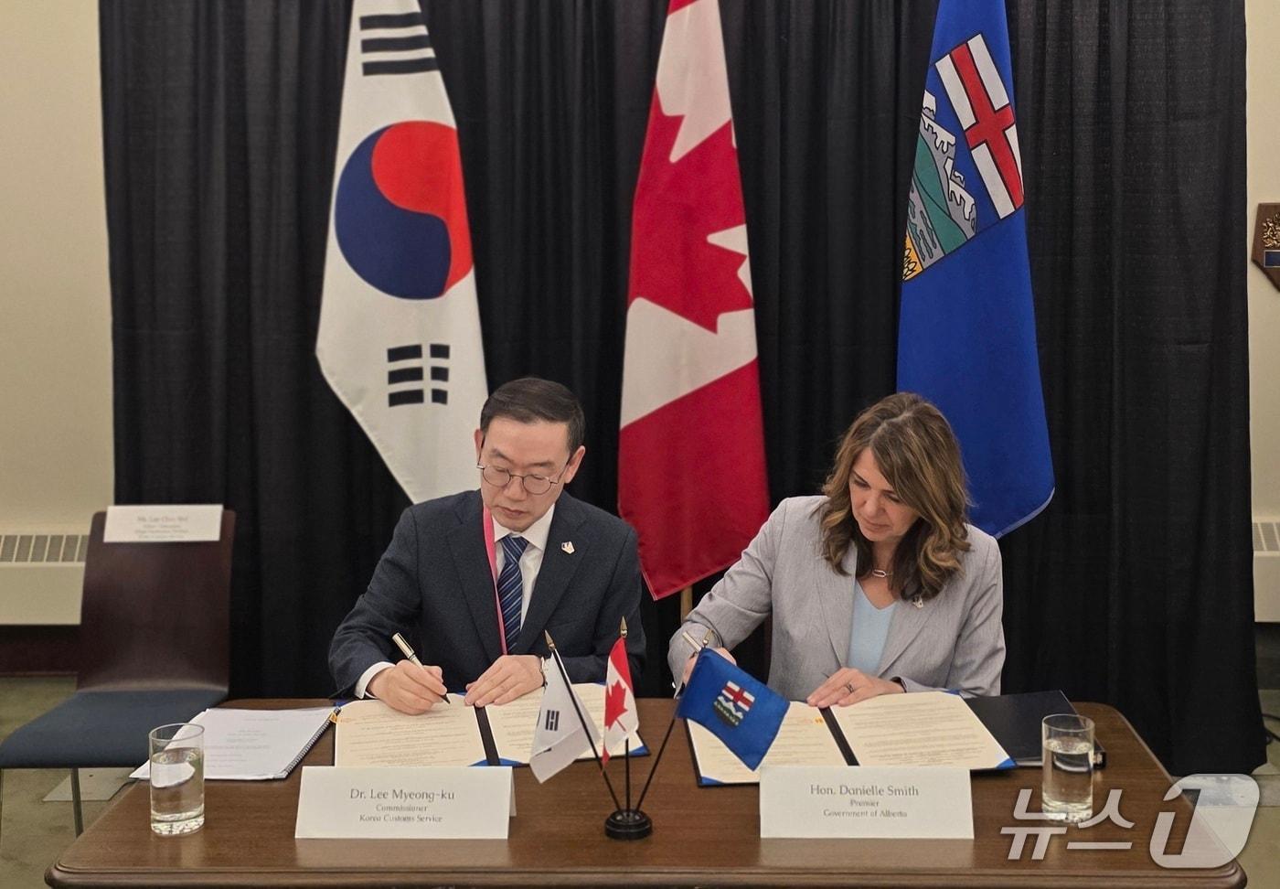 본문 이미지 - 이명구 관세청장(왼쪽)과 다니엘 스미스 앨버타 주정부 수상이 20일(현지시각) 캐나다 앨버타주 에드먼턴에서 '원산지 증빙 서류 간소화에 관한 공동성명'에 서명하고 있다.(관세청 제공.재판매 및 DB금지)/뉴스1