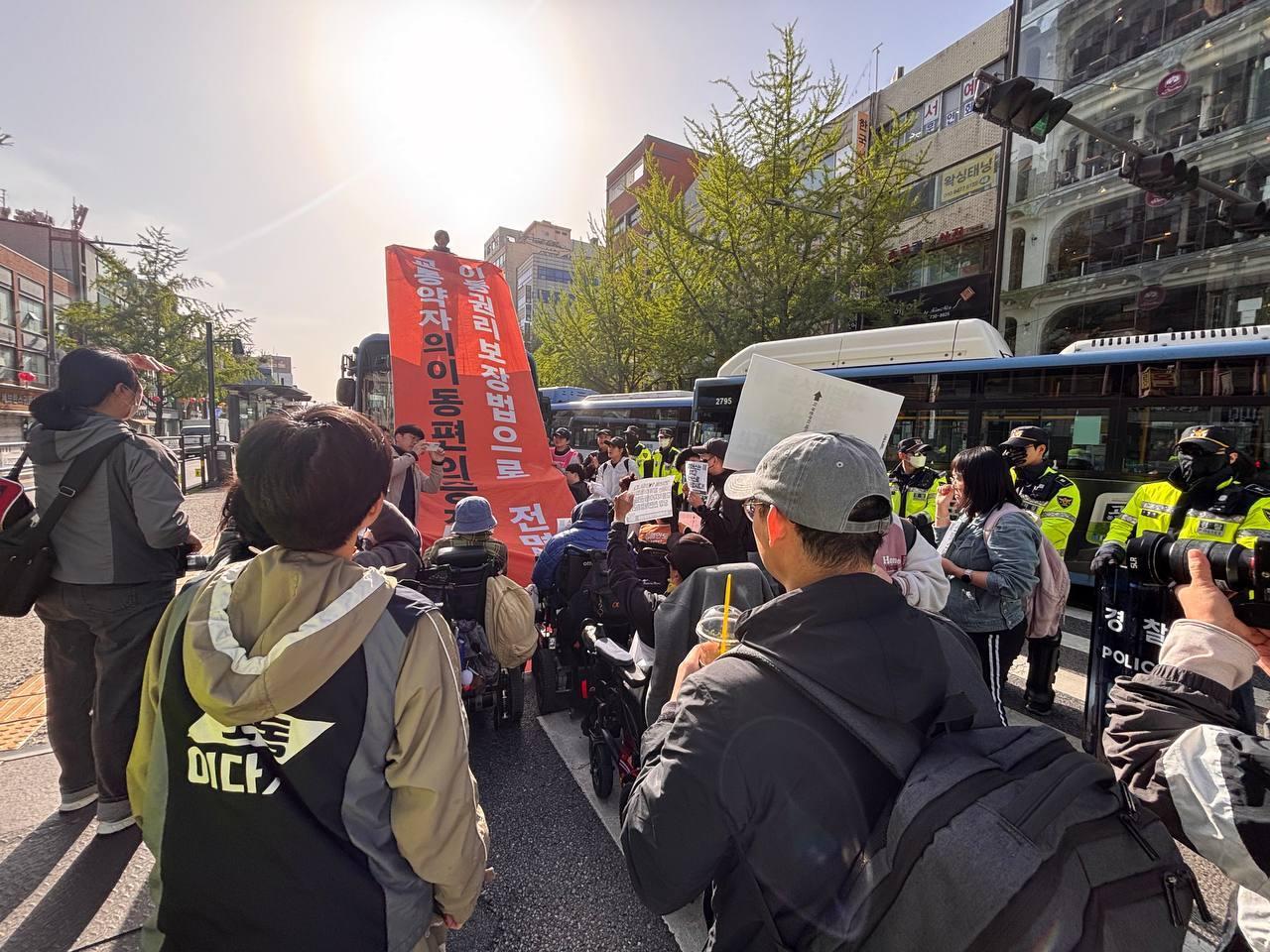 본문 이미지 - 21일 출근길 종로 일대에서 버스 저지 시위를 벌이던 전국장애인차별철폐연대 활동가의 모습(전장연 제공)
