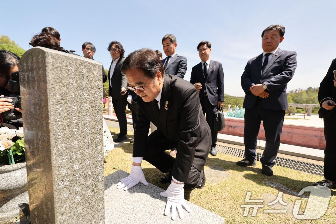 본문 이미지 - 우원식 국회의장이 21일 광주 북구 운정동 국립 5·18민주묘지에서 오월영령에 참배 후 윤상원 열사의 묘비 앞에서 무릎 꿇고 있다. 2026.4.21 ⓒ 뉴스1 박지현 기자