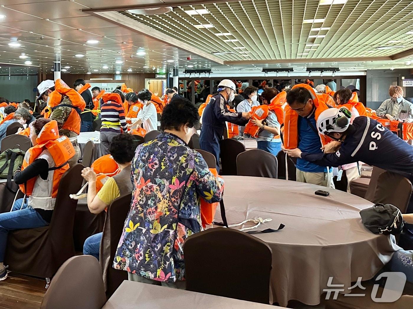 본문 이미지 - 이용객들과 구명조끼 착용을 시연(해양수산부 제공)