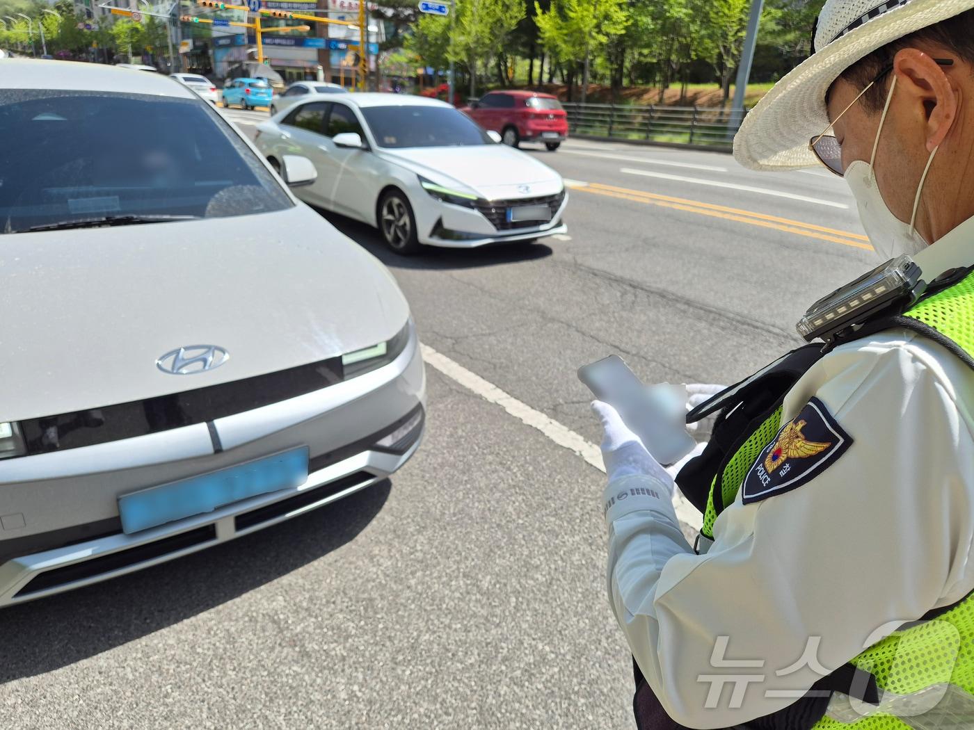 본문 이미지 - 21일 오후 울산북부경찰서 교통경찰이 북구 화봉휴먼시아 앞 사거리에서 빨간불 우회전 시 일시 정지하지 않은 SUV를 잡아 세워 범칙금을 부과하고 있다. 2026.4.21 ⓒ 뉴스1 박정현 기자