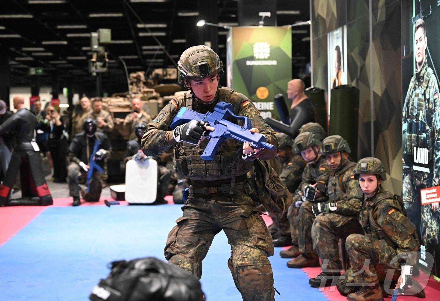 본문 이미지 - 16일(현지시간) 독일 서부 쾰른에서 열린 건강·피트니스·웰빙 박람회인 FIBO의 독일 연방군 부스에서 독일 연방군 병사들이 근접 전투 훈련을 실시하고 있다. 2026.04.16. ⓒ AFP=뉴스1