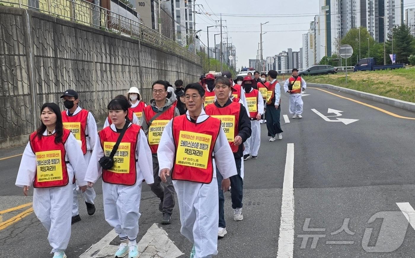 본문 이미지 - 회사의 위장 파산을 주장하며 청와대 도보 행진을 시작한 우창코넥타 직원들이 22일 천안 서북구의 한 도로에서 행진하고 있다. 이들은 일주일간 행진을 계속해 오는 28일 청와대에 도착할 예정이다. 2026.4.22 ⓒ 뉴스1 이시우 기자