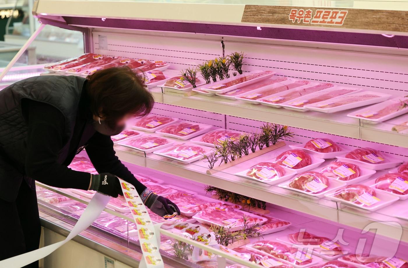 본문 이미지 -  22일 서울 서초구 농협하나로마트 양재점에서 마트 관계자가 돼지고기를 진열하고 있다. 2026.4.22 ⓒ 뉴스1 김진환 기자