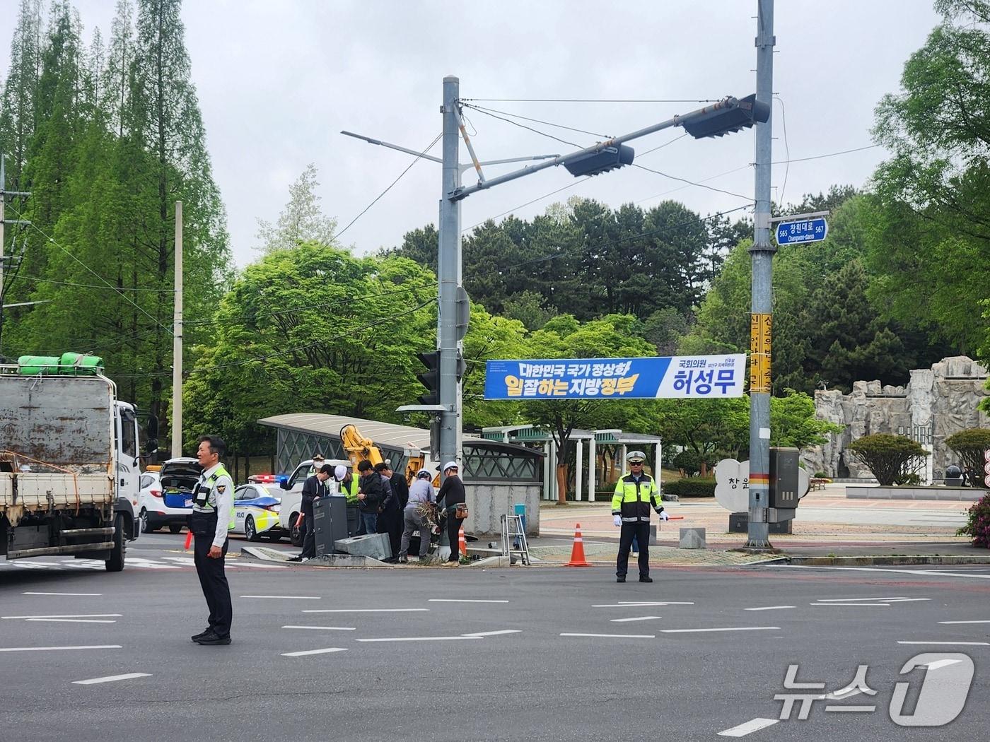 본문 이미지 - 22일 오전 9시 20분쯤 창원시 성산구 삼동동 삼동공원 사거리에서 음주 운전 차량이 신호등과 신호 제어기를 충격해 사거리 신호가 마비됐다. 사진은 사고 현장에서 경찰이 수신호로 차량 흐름을 통제하는 모습.(독자 제공. 재판매 및 DB금지)