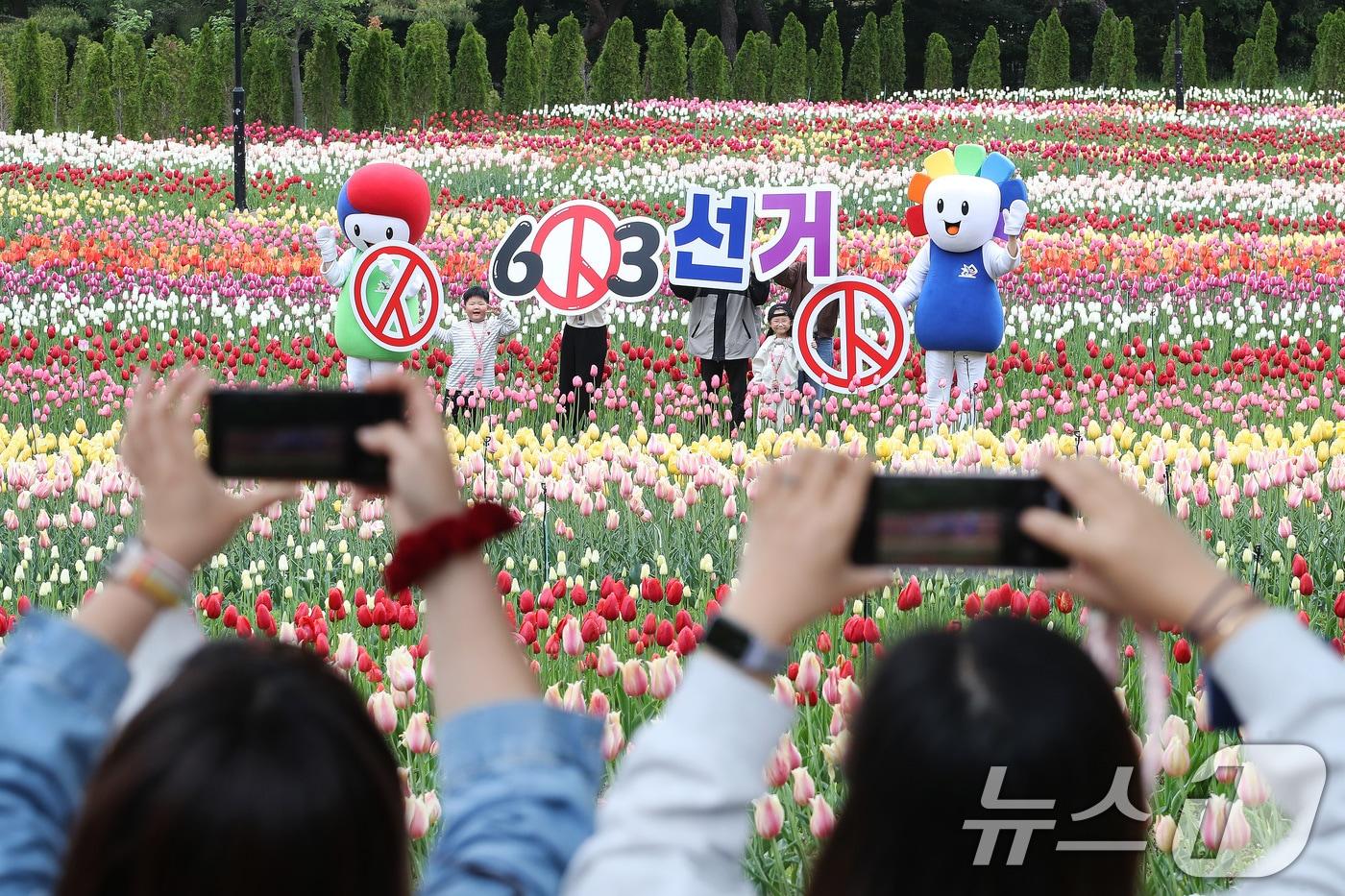 본문 이미지 - 제9회 전국동시지방선거가 42일 앞으로 다가온 22일 대구 달서구 테마파크 이월드 튤립 정원에서 대구시선거관리위원회 관계자와 선거 마스코트가 어린이와 함께 지방선거 투표 참여 캠페인을 펼치고 있다. 2026.4.22 ⓒ 뉴스1 공정식 기자