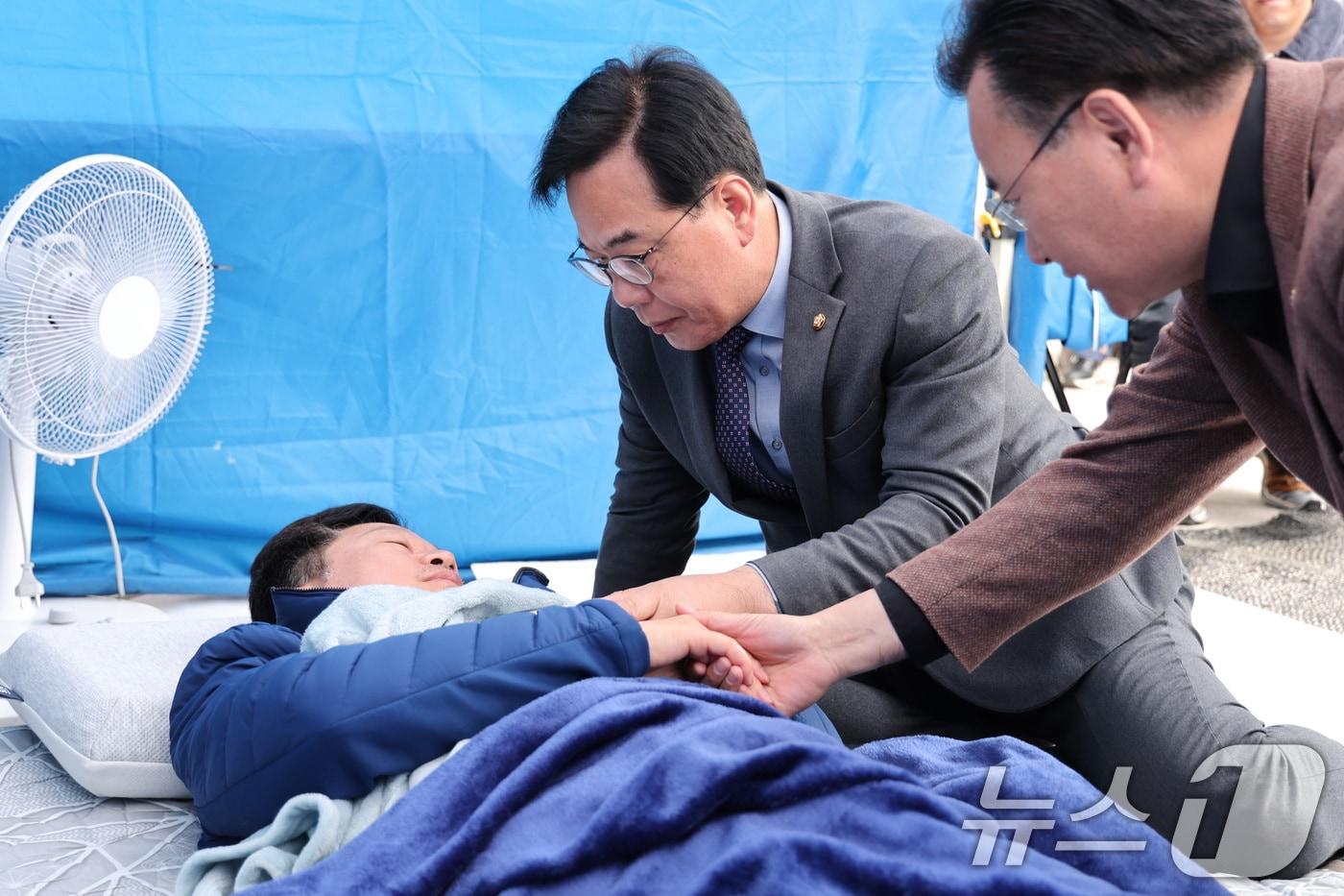 본문 이미지 - 송언석 국민의힘 원내대표가 22일 서울 여의도 본관 앞에서 단식 농성 중인 안호영 더불어민주당 의원을 방문해 대화하고 있다. ⓒ 뉴스1 신웅수 기자