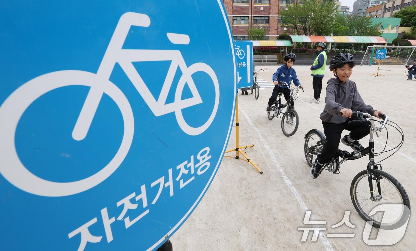 본문 이미지 - 자전거의 날인 22일 경기 수원시 권선구 명당초등학교에서 열린 '2026년 찾아가는 자전거&PM(개인형 이동장치) 안전교육'에서 학생들이 교통표지판과 법규 등 안전 주행 방법을 '자전거와환경 사회적협동조합' 관계자들에게 교육받고 있다. 2026.4.22 ⓒ 뉴스1 김영운 기자