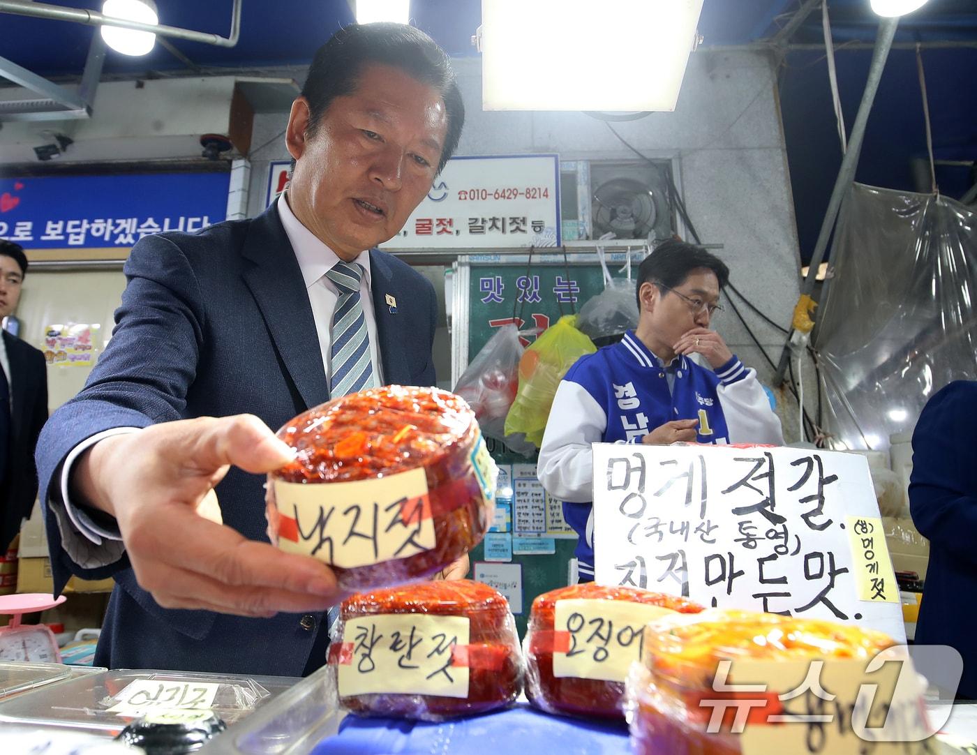 본문 이미지 - 정청래 더불어민주당 대표가 22일 경남 통영 통영중앙전통시장을 찾아 낙지젓을 들어 보이고 있다. 2026.4.22 ⓒ 뉴스1 윤일지 기자