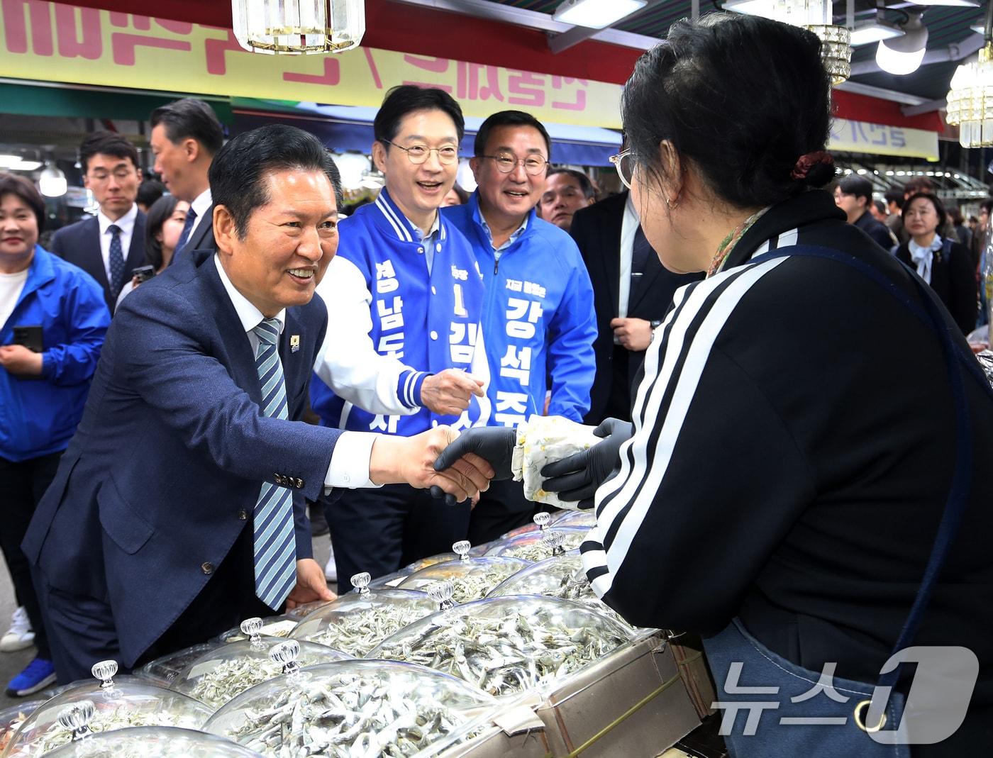 본문 이미지 - 정청래 더불어민주당 대표가 22일 경남 통영 통영중앙전통시장을 찾아 김경수 경남도지사 후보, 강석주 통영시장 후보와 함께 상인과 인사를 나누고 있다. 2026.4.22 ⓒ 뉴스1 윤일지 기자