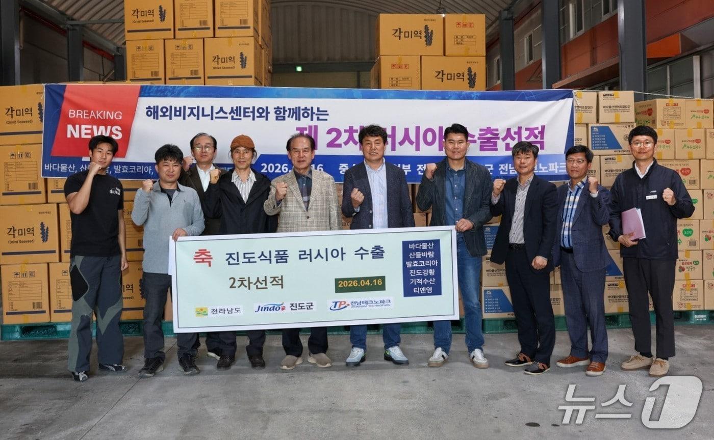 본문 이미지 - 진도 농수산 가공식품의 러시아 수출 선적식에서 김희수 군수(왼쪽에서 다섯번째)를 비롯한 진도군 관계자들이 기념사진을 찍고 있다.(진도군 제공, 재판매 및 DB금지)/뉴스1 