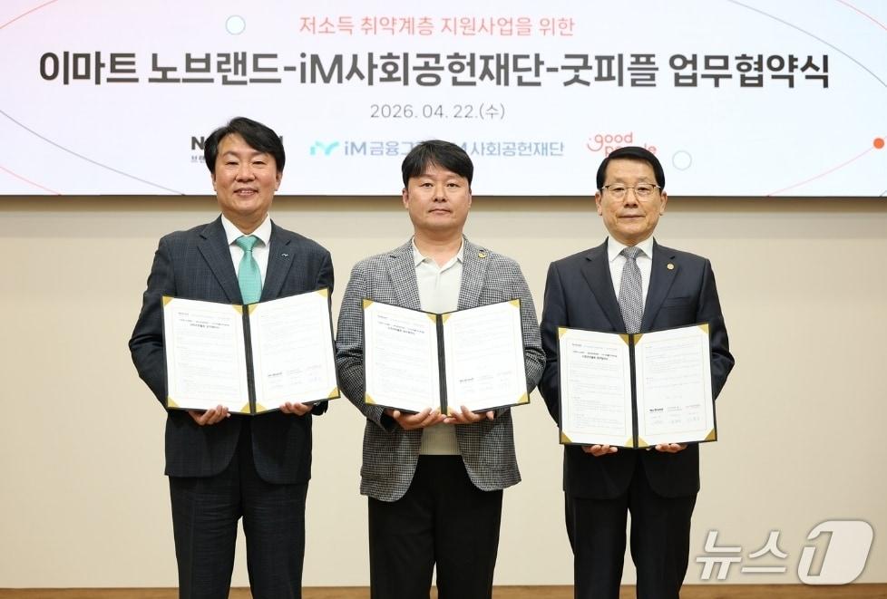 본문 이미지 - 신용필 iM금융지주 그룹가치경영총괄 전무(왼쪽)와 서혁진 이마트 노브랜드 상무(가운데), 장용환 굿피플인터내셔널 운영부회장이 저소득 취약계층 지원 사업을 위한 업무협약을 체결한 뒤 협역서를 펼쳐 보이고 있다.(iM뱅크 제공, 재판매 및 DB 금지)