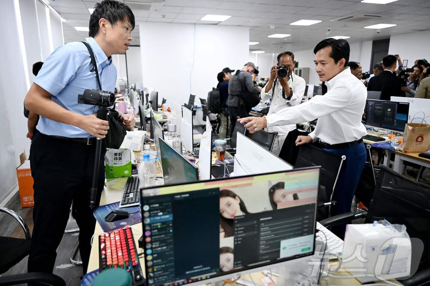 본문 이미지 - 텝 아스나릿 캄보디아 정보부 차관 겸 대변인이 3월 프놈펜 사이버 사기 센터에서 압수된 모니터를 살펴보고 있다. 2026.3.11 ⓒ AFP=뉴스1