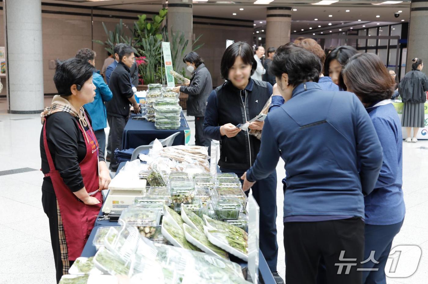 본문 이미지 - 시민들이 판매 부스에서 산나물을 구매하는 모습(산림조합중앙회 제공.재판매 및 DB금지)/뉴스1