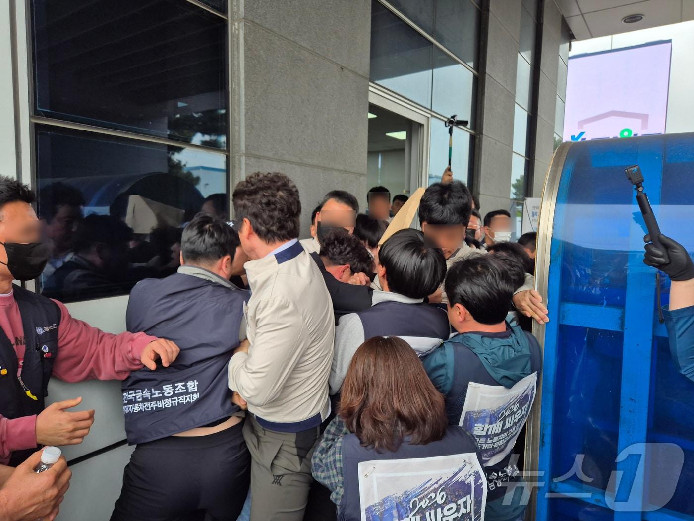 본문 이미지 - 전국금속노동조합이 22일 현대자동차 울산공장 정문에서 원청교섭를 촉구하며 교섭요구안을 전달하기 위해 공장 진입을 시도하다, 저지하는 현대차 보안요원들과 충돌하고 있다. 2026.4.22 ⓒ 뉴스1 박정현 기자