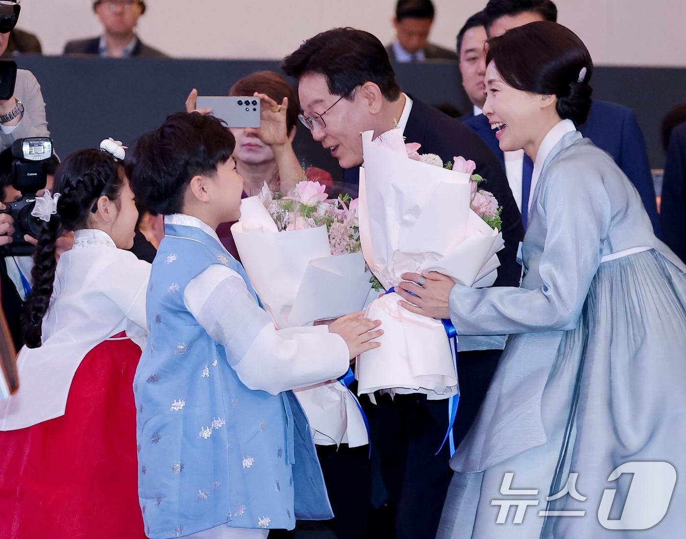 본문 이미지 - 베트남을 국빈 방문 중인 이재명 대통령과 김혜경 여사가 22일(현지시간) 하노이의 한 호텔에서 열린 동포 오찬 간담회에서 화동에게 꽃다발을 받고 있다. 2026.4.22 ⓒ 뉴스1 이재명 기자