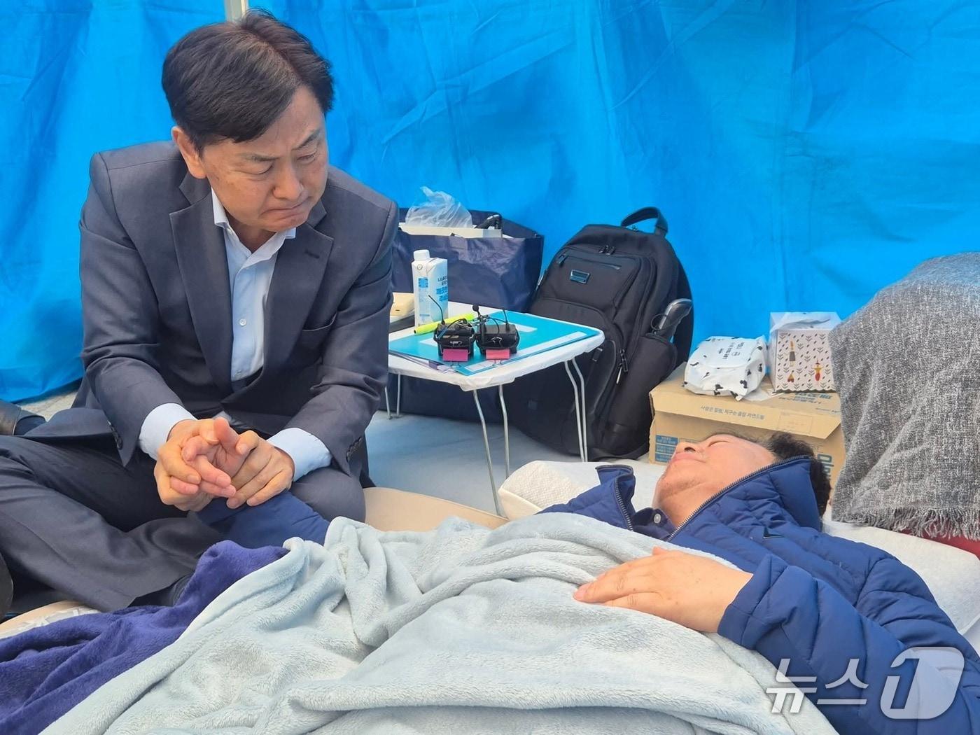 본문 이미지 - 22일 국회 앞 안호영 의원 단식 농성장을 방문한 김관영 전북지사가 굳은 얼굴로 안 의원의 손을 잡고 있다.(김관영 전북지사 페이스북 인용. 재판매 및 DB금지)/뉴스1  