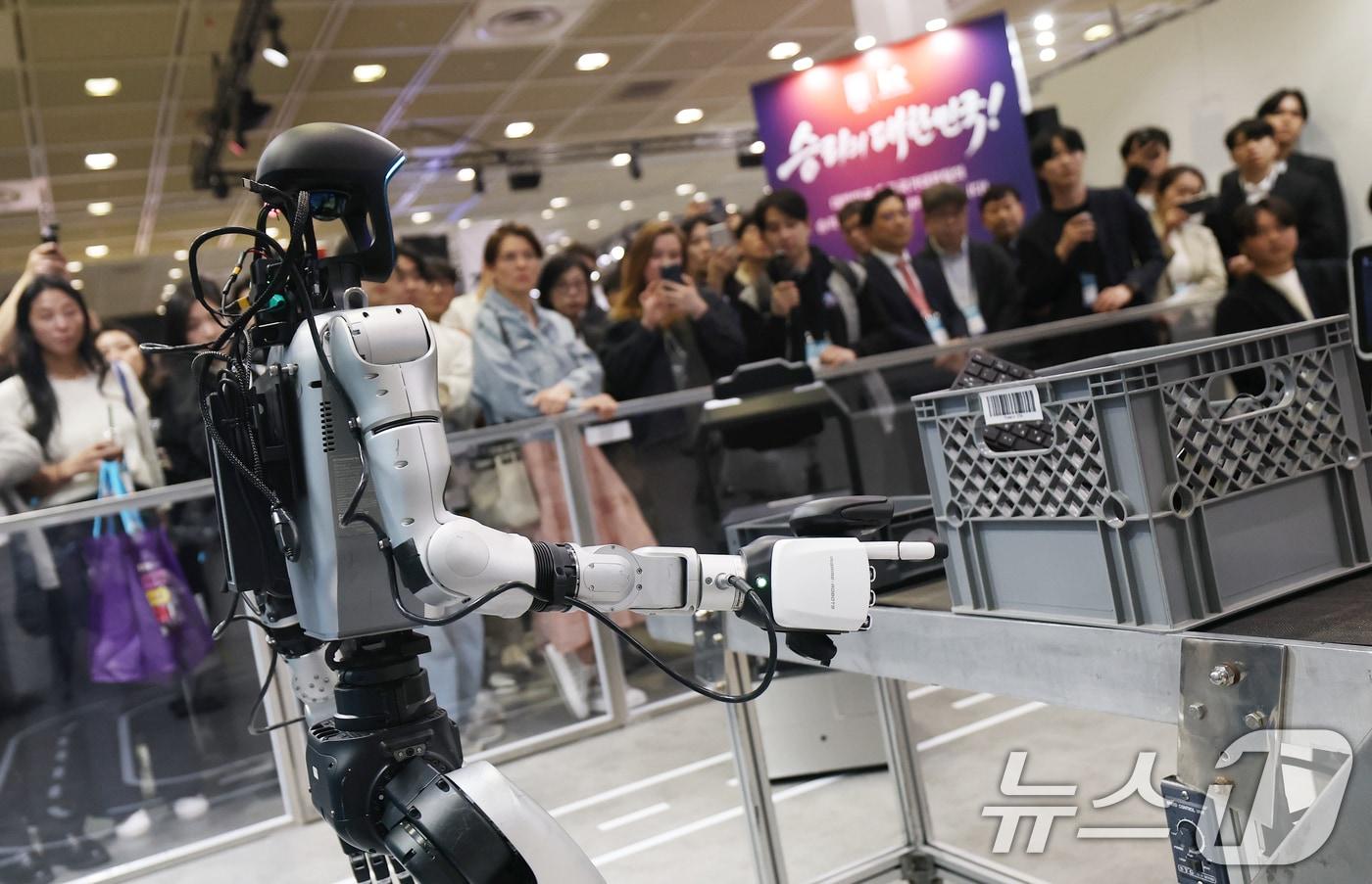 본문 이미지 - 22일 서울 강남구 코엑스에서 열린 '2026 월드IT쇼'(WIS 2026)를 찾은 관람객들이 KT 부스에서 K-RaaS 플랫폼을 활용한 산업 현장 피지컬 AI 시연을 지켜보고 있다. 2026.4.22 ⓒ 뉴스1 오대일 기자
