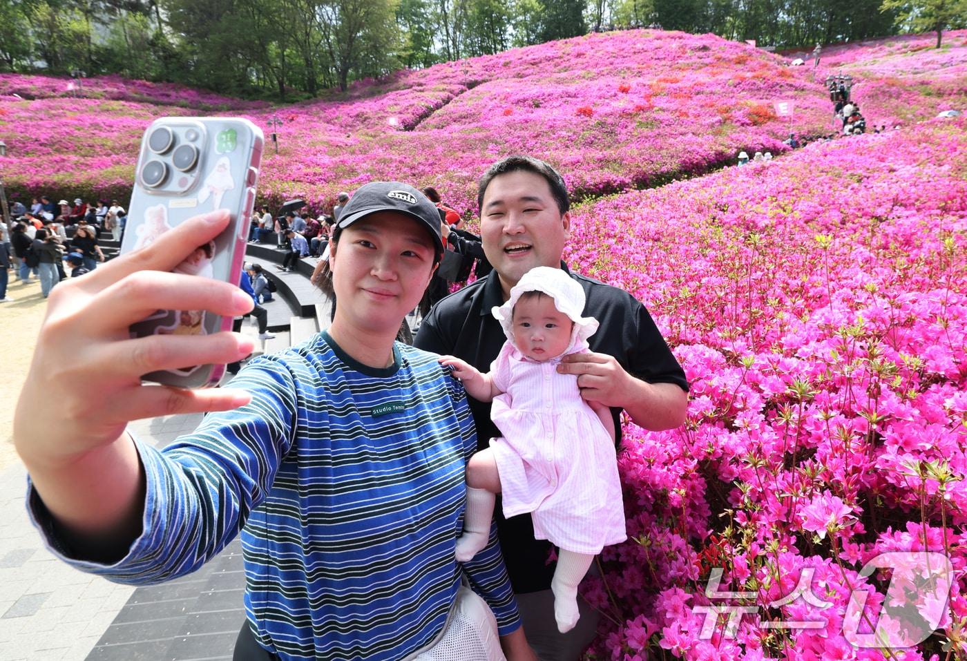 본문 이미지 - 군포철쭉축제가 열리고 있는 22일 경기 군포시 철쭉동산에서 한 가족이 만개한 철쭉을 배경으로 기념촬영을 하고 있다. 2026.4.22 ⓒ 뉴스1 김영운 기자