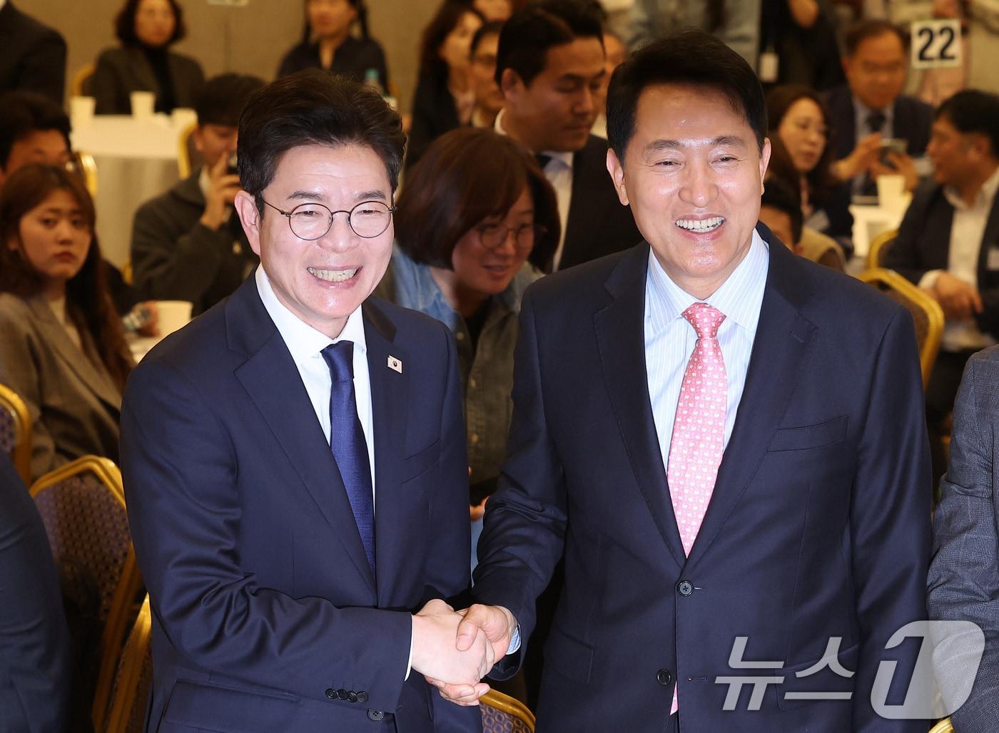 본문 이미지 - 오세훈 서울시장(오른쪽)과 정원오 더불어민주당 서울시장 후보가 22일 서울 용산구 백범김구기념관 컨벤션홀에서 열린 서울시사회복지사협회 창립 40주년 기념식에서 인사하고 있다. 2026.4.22 ⓒ 뉴스1 김성진 기자