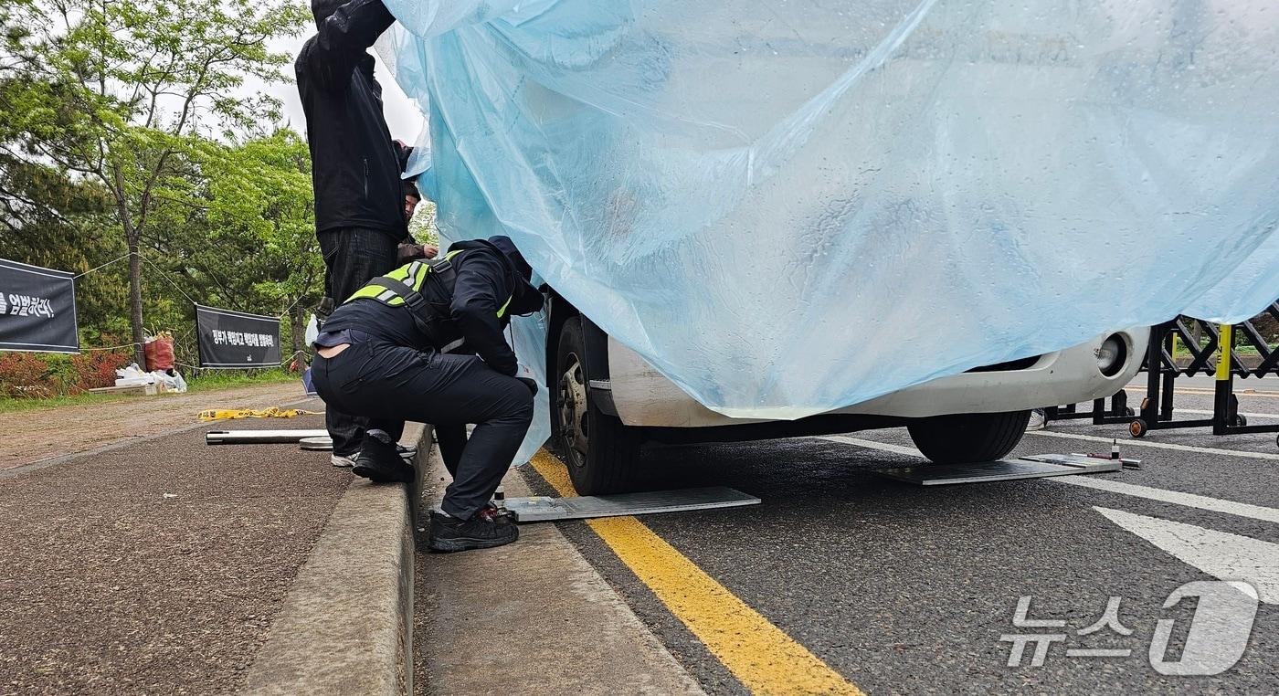 본문 이미지 - 경찰이 화물연대 조합원을 친 차 감식을 위한 사전 작업으로 22일 사고 현장에 세워진 차량의 무게를 측정하고 있다. 2026.4.22/뉴스1 한송학기자