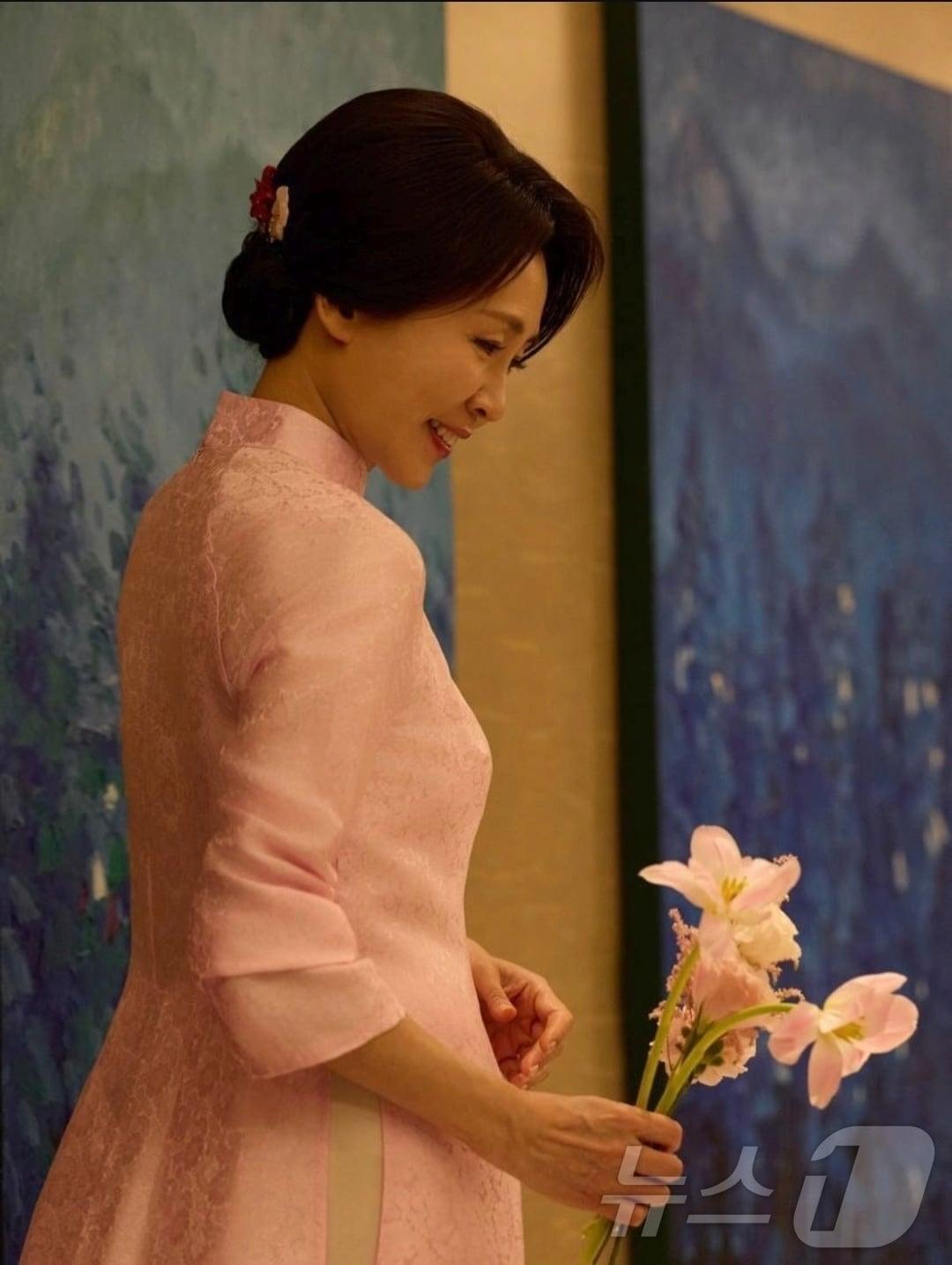 본문 이미지 - 또 럼 베트남 공산당 서기장 부인 응오 프엉 리 여사가 선물한 분홍색 아오자이를 입고 있는 김혜경 여사.(이재명 대통령 인스타그램 갈무리) ⓒ 뉴스1 한재준 기자