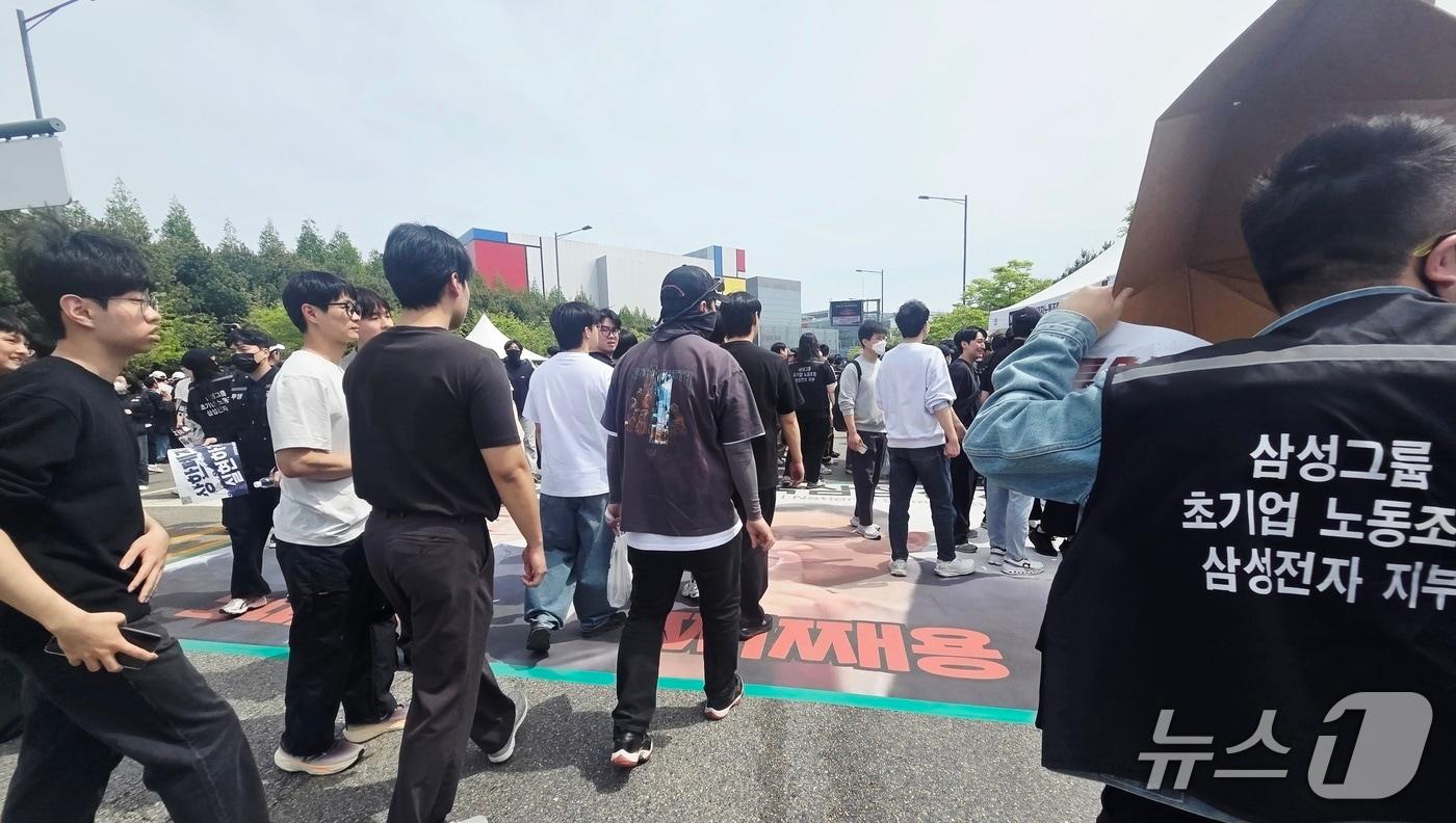 본문 이미지 - 23일 경기 평택시 고덕동 삼성전자 평택캠퍼스에서 열린 삼성전자 노동조합 공동투쟁본부 '4·23 투쟁 결의대회'에서 이재용 삼성전자 회장, 전영현 삼성전자 대표이사 부회장, 노태문 삼성전자 사장의 사진을 밟고 지나가고 있다. 2026.4.23 ⓒ 뉴스1 박기범 기자  