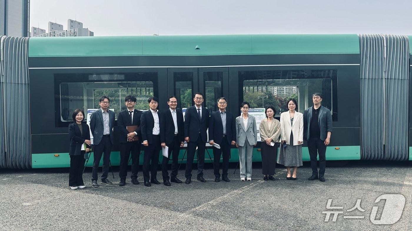 본문 이미지 - 행복도시 광역계획권교통협의회 위원들이 23일 3칸 굴절버스에 대한 설명을 듣고 있다. (시 제공) / 뉴스1