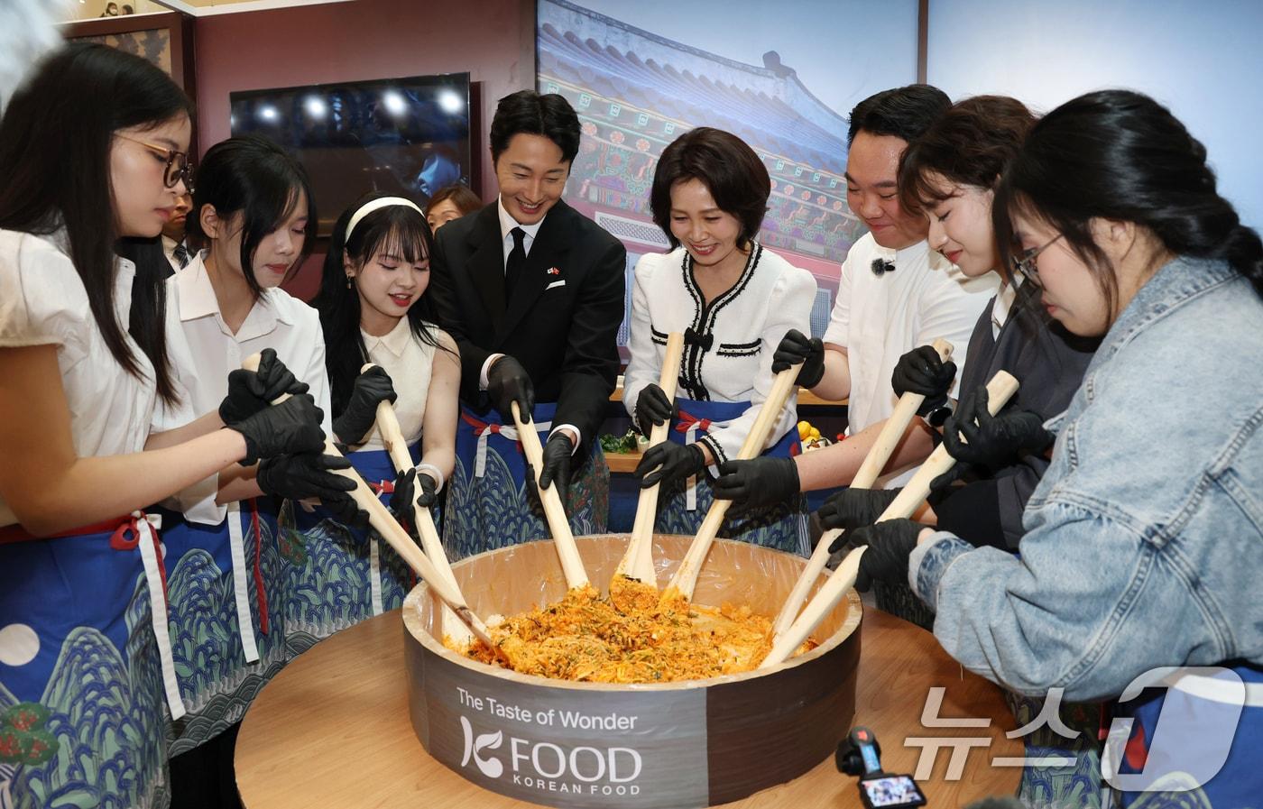 본문 이미지 - 이재명 대통령과 베트남을 방문 중인 김혜경 여사가 23일(현지시간) 하노이 서호 롯데몰에서 열린 K문화관광대전에서 배우 정일우 등 참석자들과 비빔밥을 만들고 있다. 2026.4.23 ⓒ 뉴스1 이재명 기자
