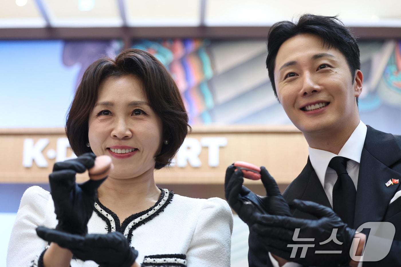 본문 이미지 - 이재명 대통령과 베트남을 국빈 방문 중인 김혜경 여사가 23일(현지시간) 하노이 롯데몰에서 열린 K문화관광대전에서 배우 정일우와 직접 만든 마카롱을 들어보이고 있다. 2026.4.23 ⓒ 뉴스1 이재명 기자