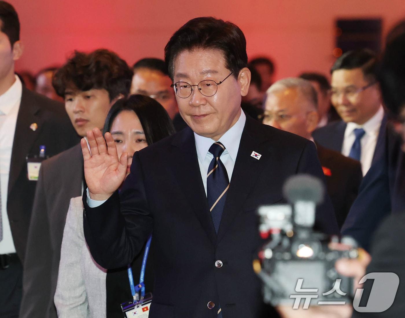 본문 이미지 - 베트남을 국빈 방문 중인 이재명 대통령이 23일(현지시간) 하노이 한 호텔에서 열린 한-베트남 비즈니스 포럼을 마친 뒤 퇴장하며 손을 들어 인사를 하고 있다. 2026.4.23 ⓒ 뉴스1 이재명 기자