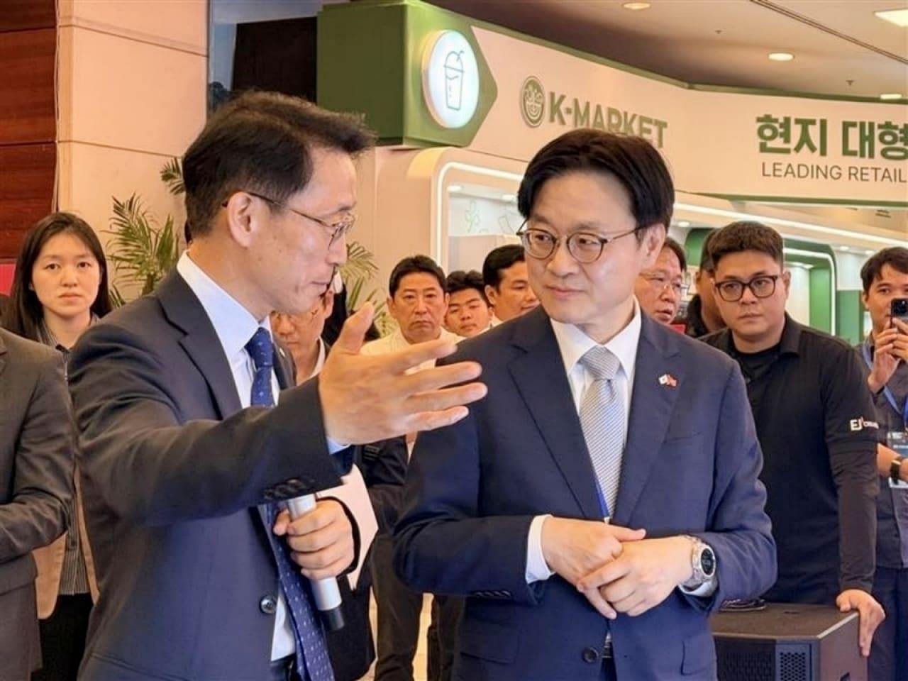 본문 이미지 - 롯데홈쇼핑은 23일 베트남 하노이에서 열린 한-베트남 비즈니스 파트너십에서 국내 중소기업의 베트남 진출을 지원하는 쇼케이스와 수출 상담을 진행했다. 김재겸 롯데홈쇼핑 대표(왼쪽)가 김정관 산업통상부 장관(오른쪽)에게 롯데홈쇼핑 부스를 설명하는 모습(롯데홈쇼핑 제공)