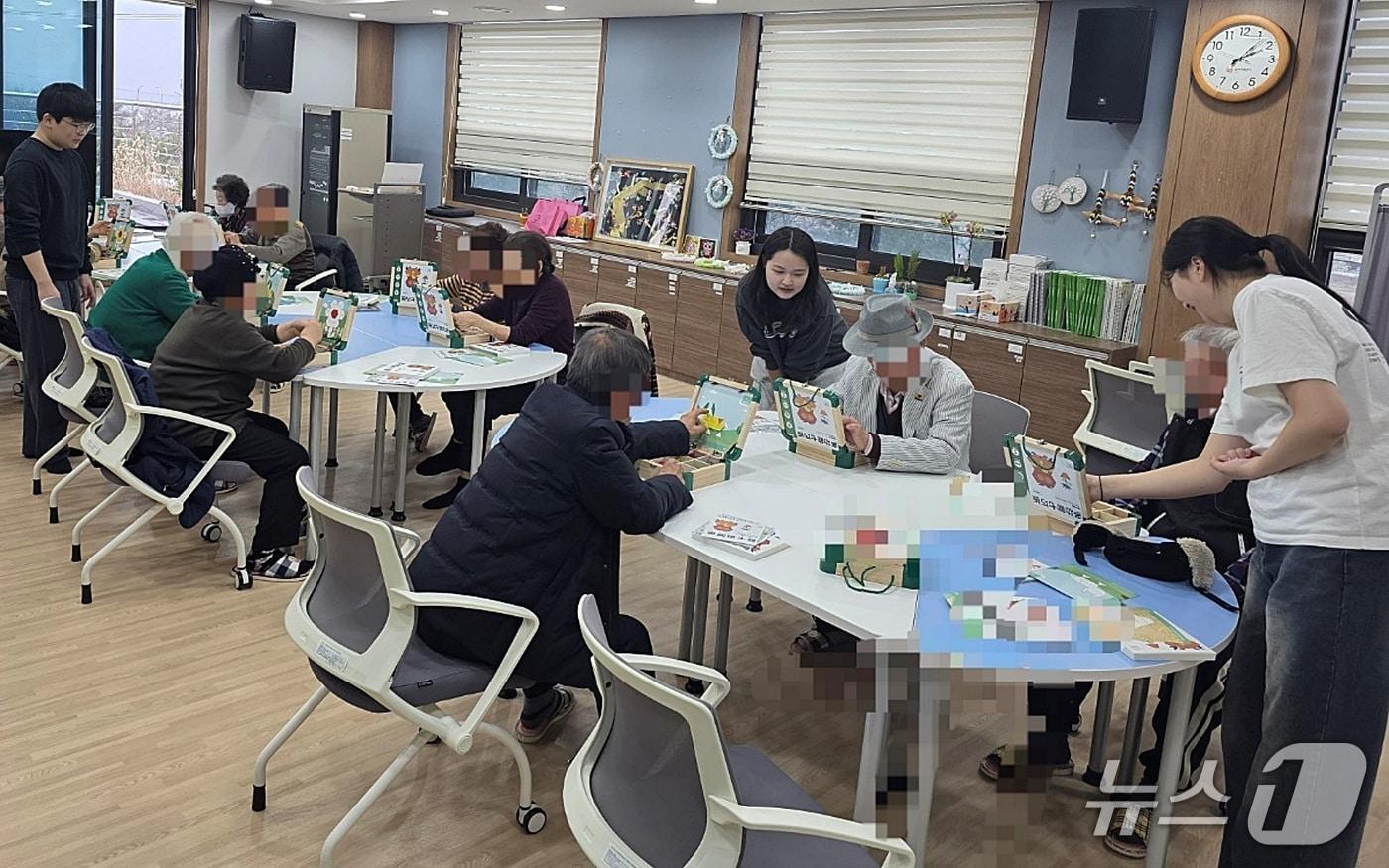 본문 이미지 - 중원대학교 작업치료학과 치매 서포터즈 학생들이 괴산군보건소 치매안심센터 '기억올림' 프로그램에 동참해 경증 치매 노인들을 돌보고 있다(괴산군 제공. 재판매 및 DB금지)