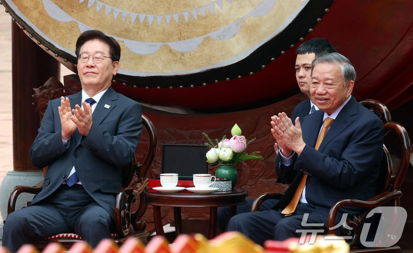 본문 이미지 - 이재명 대통령과 또 럼 베트남 당 서기장 겸 국가주석이 24일(현지시간) 친교일정으로 베트남 탕롱 황성를 방문해 전통공연을 관람하며 박수 치고 있다. 2026.4.24 ⓒ 뉴스1 이재명 기자