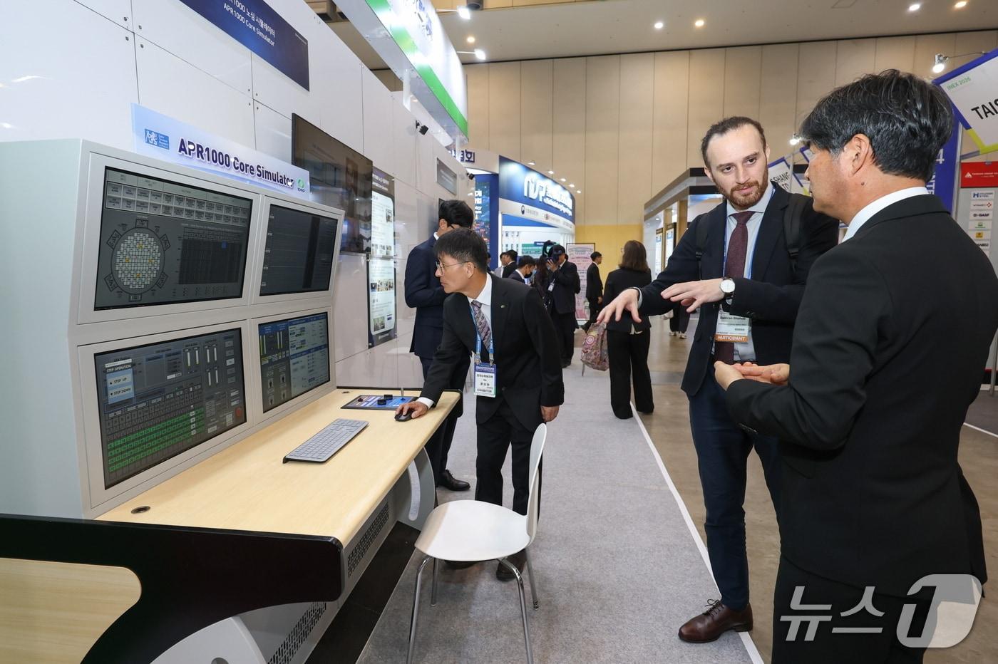 본문 이미지 - 해외 참가자가 한수원 '원자력 연구개발(R&D) 성과전시관'을 찾아 설명을 듣고 있다.(사진제공=한수원)