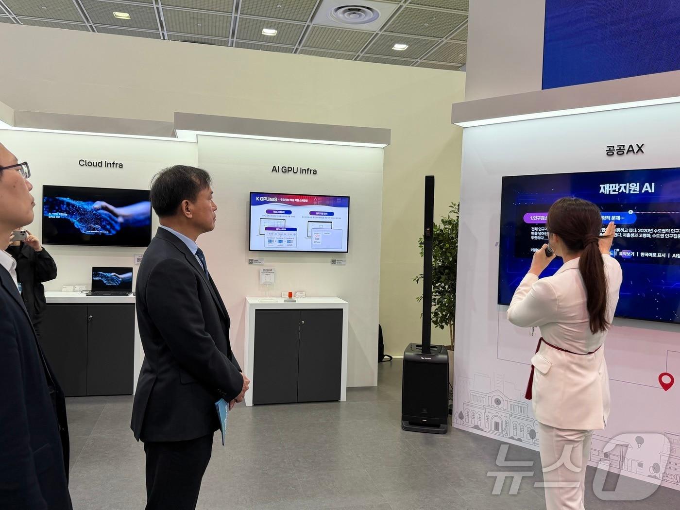 본문 이미지 - 김종철 방송미디어통신위원회 위원장이 24일 서울 강남구 코엑스에서 열린 월드IT쇼 2026 KT 부스에서 재난지원 AI 등 공공 AI 전환 서비스 설명을 듣고 있다. 2026.4.24 ⓒ 뉴스1