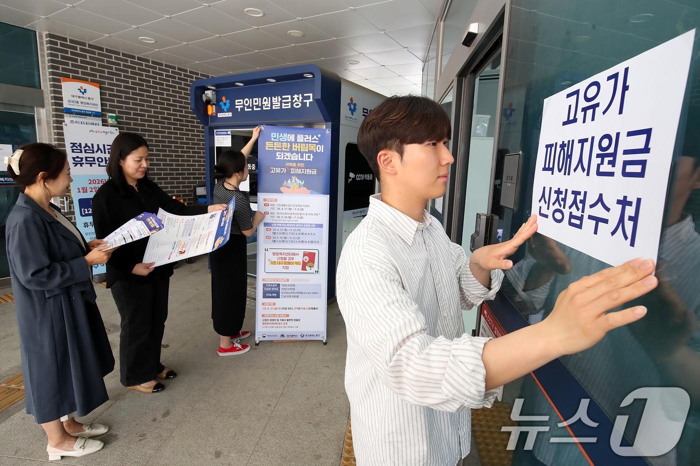 본문 이미지 - 다음 주 월요일(27일) 시작되는 '고유가 피해지원금' 신청 접수를 앞두고 24일 대구 중구 성내3동 행정복지센터에서 직원들이 안내문을 붙이고 있다. 2026.4.24 ⓒ 뉴스1 공정식 기자