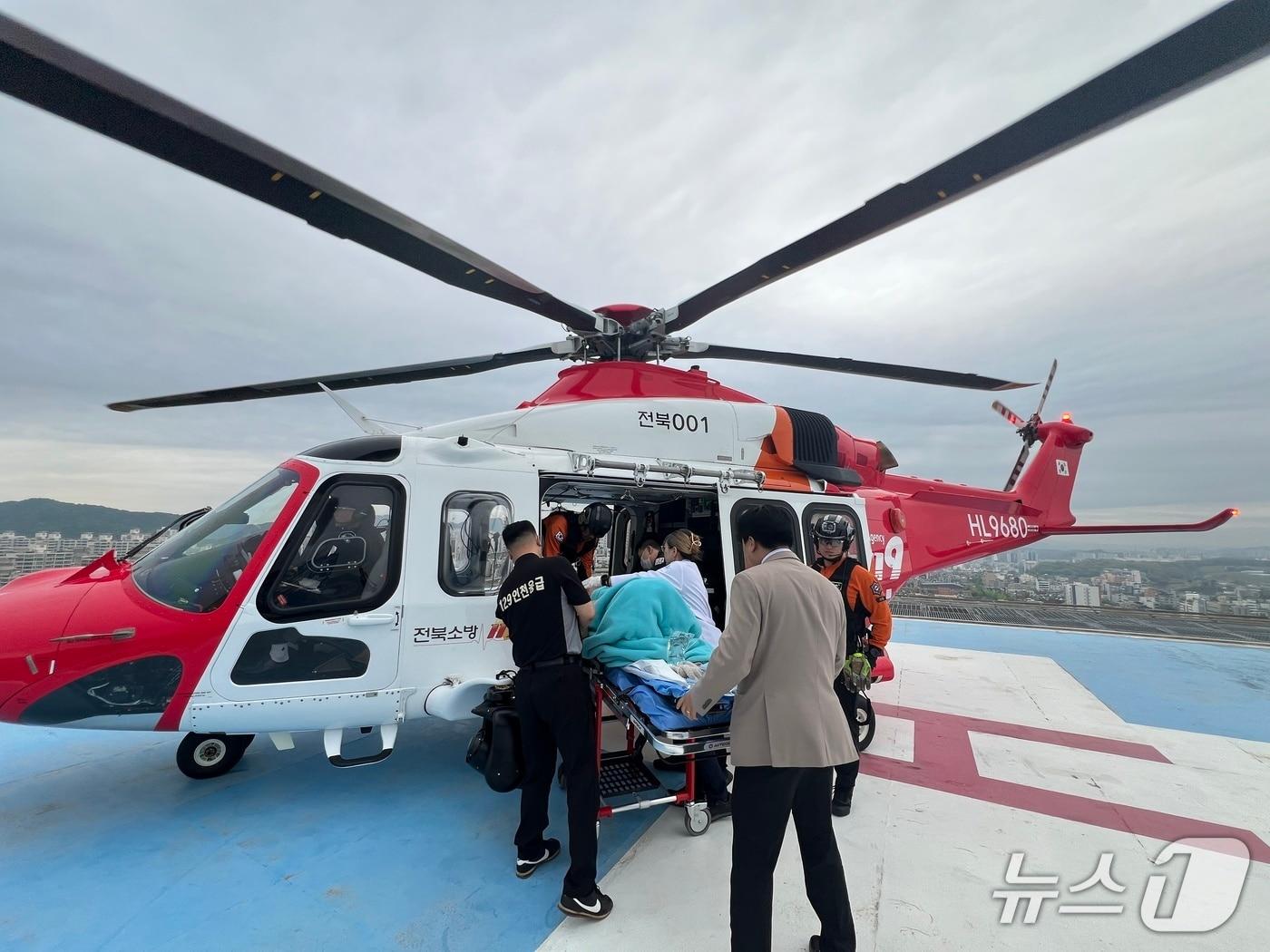 본문 이미지 - 지난 20일 전북 전주에서 조기 진통이 발생한 24주 고위험 임산부를 안전하게 이송하기 위해 총 360km를 비행한 전북 1호 소방헬기가 인천 가천대 길병원 옥상 헬리패드에 착륙해 대기 중이던 의료진에게 환자를 무사히 인계하고 있다.(소방청 제공)