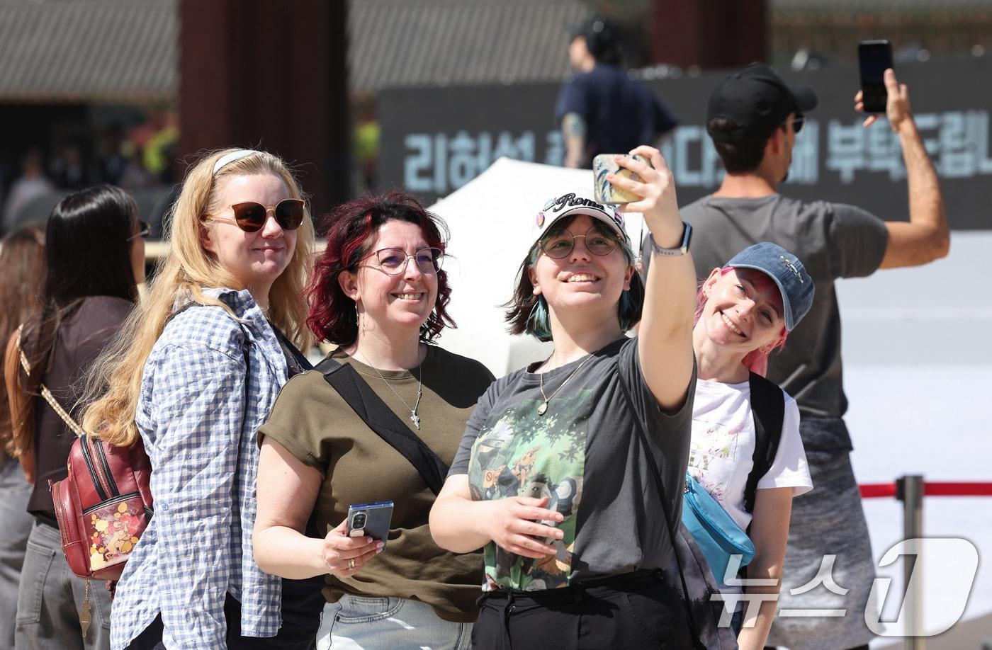 본문 이미지 - 서울 낮 최고 기온이 26도까지 올라가는 등 초여름 날씨를 보인 24일 서울 종로구 경복궁을 찾은 외국인 관광객이 친구들과 함께 사진을 찍고 있다. 2026.4.24 ⓒ 뉴스1 임지훈 인턴기자