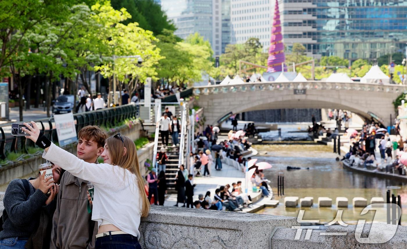 본문 이미지 - 낮 최고기온이 26도까지 오르며 초여름 날씨를 보인 24일 오후 서울 청계천을 찾은 외국인 관광객들이 더위를 식히고 있다. 2026.4.24 ⓒ 뉴스1 조연우 인턴기자