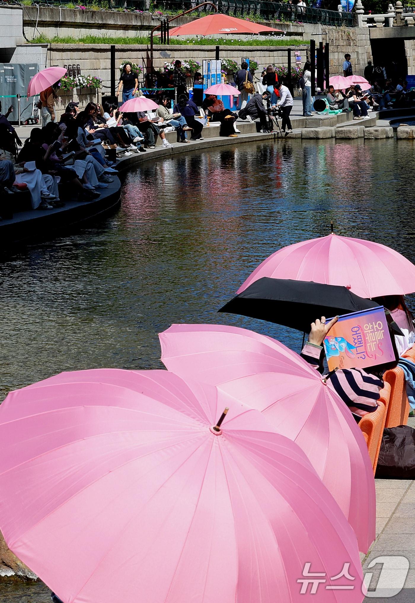 본문 이미지 - 낮 최고기온이 26도까지 오르며 초여름 날씨를 보인 지난 24일 오후 서울 청계천을 찾은 외국인 관광객들이 더위를 식히고 있다. 2026.4.24 ⓒ 뉴스1 조연우 인턴기자