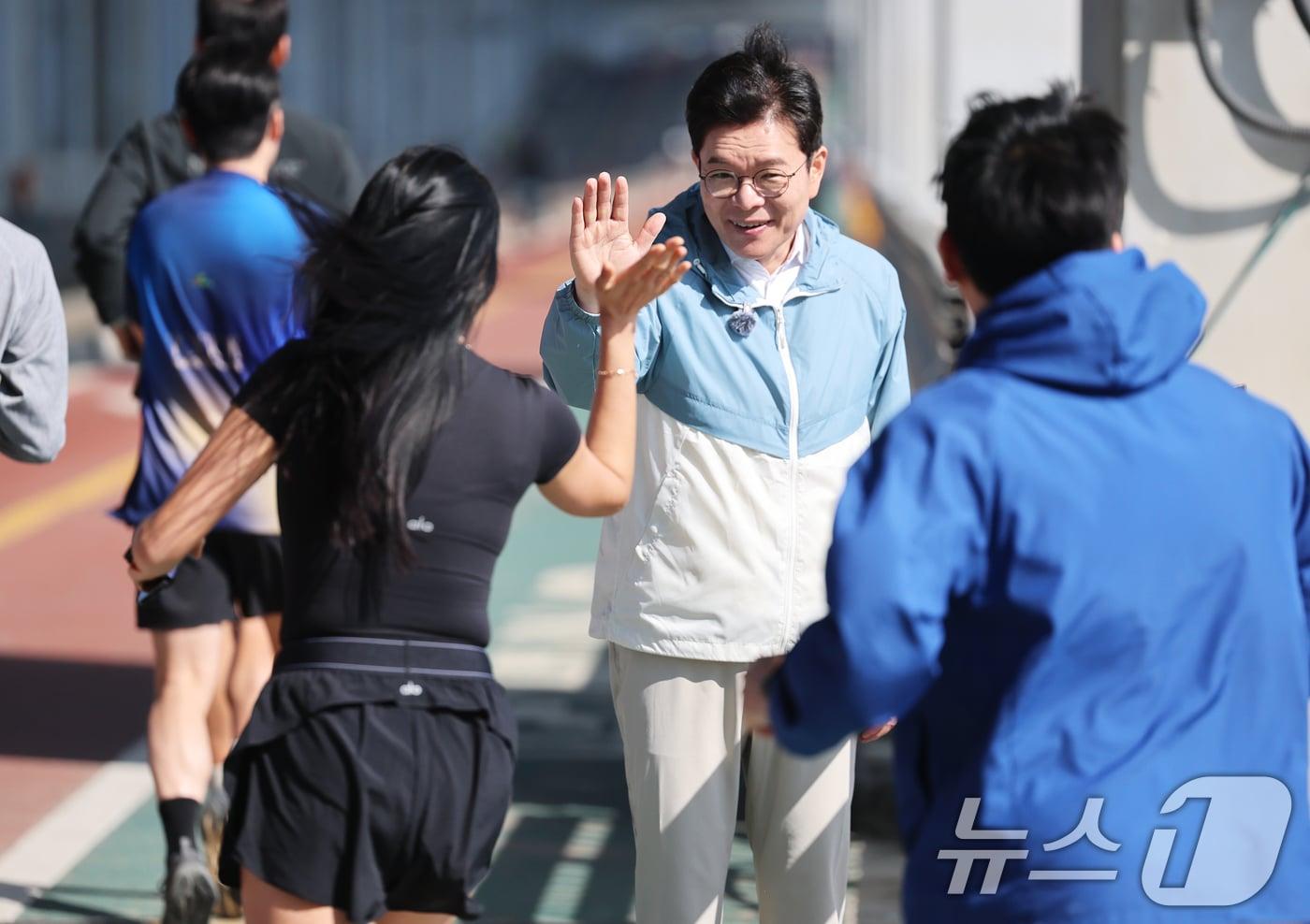 본문 이미지 - 정원오 더불어민주당 서울시장 후보가 25일 오전 서울 서초구 반포한강공원에서 열린 '찾아가는 현장: 러닝편'에서 러너들과 하이파이브를 나누고 있다. 2026.4.25 ⓒ 뉴스1 오대일 기자