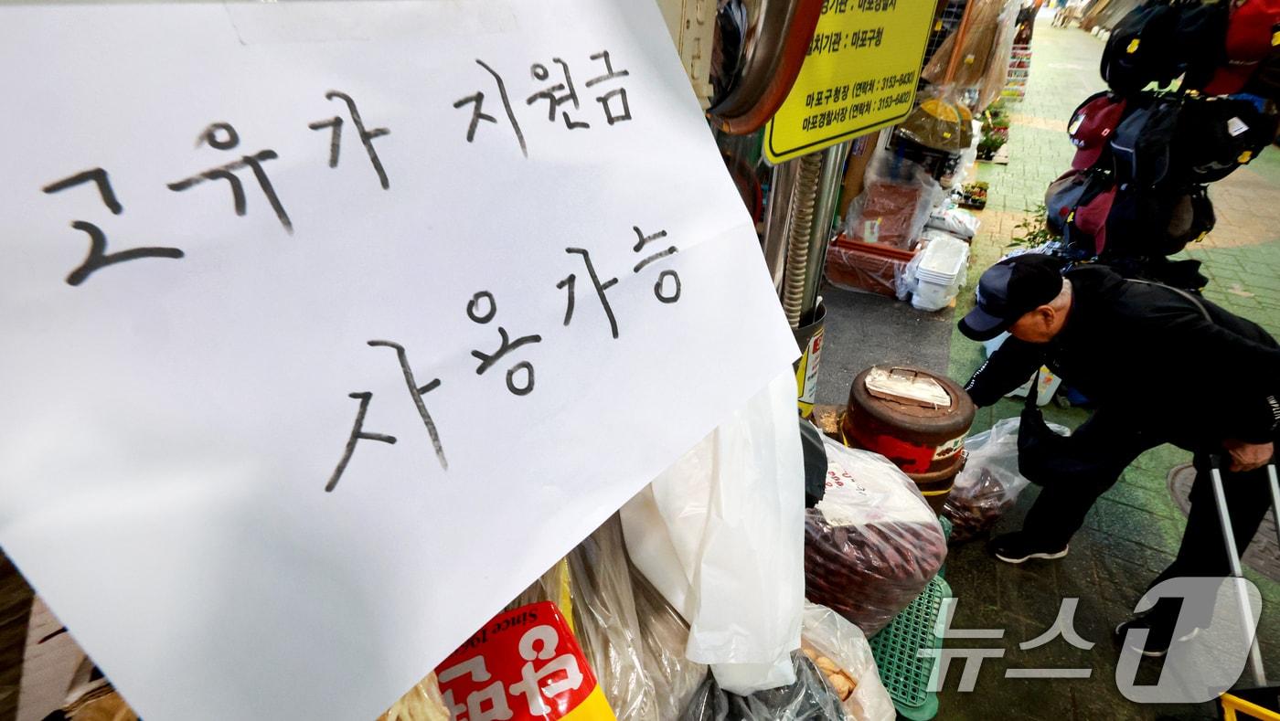 본문 이미지 - 정부의 고유가 피해지원금 1차 지급 신청을 하루 앞둔 26일 서울 마포구 망원시장에 '고유가 지원금' 사용가능 문구가 붙어 있다. 고유가 피해지원금은 소득 하위 70%를 대상으로 1인당 10만~60만원까지 차등 지급된다. 지급 방식은 신용·체크카드, 선불카드, 지역사랑상품권 중 선택할 수 있으며 신청 첫 주는 혼잡 방지를 위해 출생연도 끝자리를 기준으로 하는 '요일제'가 적용될 예정이다. 2026.4.26 ⓒ 뉴스1 이호윤 기자