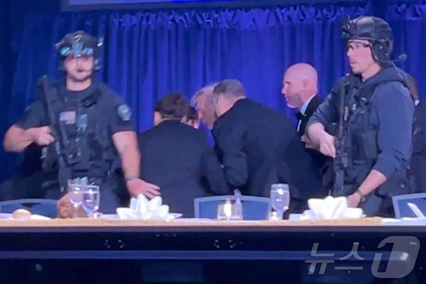 본문 이미지 - 도널드 트럼프 미국 대통령이 25일(현지시간) 워싱턴 DC의 워싱턴 힐튼호텔에서 열린 백악관 기자단 만찬 행사에서 총격소리가 나자 경호를 받으며 대피하고 있다. 트럼프 대통령은 무사 피신했으며 용의자는 체포 된것으로 알려졌다. ⓒ 로이터=뉴스1