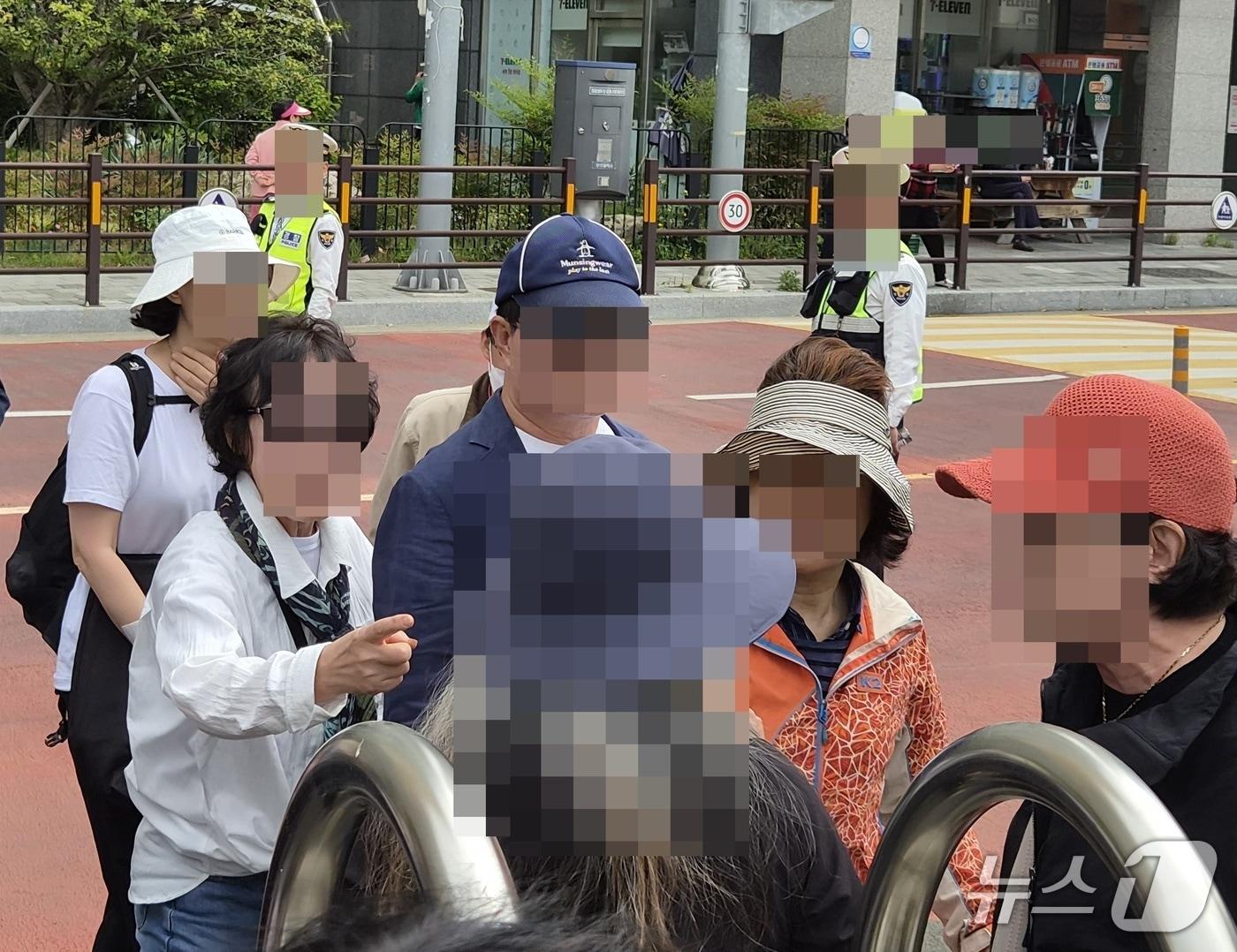 본문 이미지 - 구포초 체육대회 행사 밖에서 한 여성이 한 전 대표를 향해 "배신자"라고 고성을 지르자 한 전 대표 지지자로 보이는 또 다른 여성들과 실랑이를 하는 모습.2026.4.26/뉴스1 ⓒ News1 임순택 기자