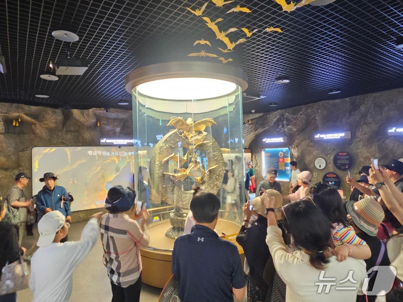본문 이미지 - 26일 오전 전남 함평 나비대축제를 찾은 시민들이 몸값만 360억 원에 달하는 '황금박쥐상'을 바라보며 감탄사를 내고 있다. 2026.4.26/뉴스1 최성국 기자