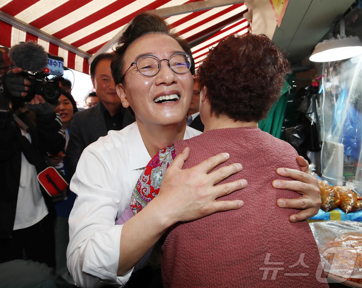 본문 이미지 - 전재수 더불어민주당 부산시장 후보가 27일 오후 부산 북구 구포시장에서 열린 '북구 주민 감사 인사' 행사를 마친 뒤 상인과 포옹하고 있다. 2026.4.27 ⓒ 뉴스1 윤일지 기자