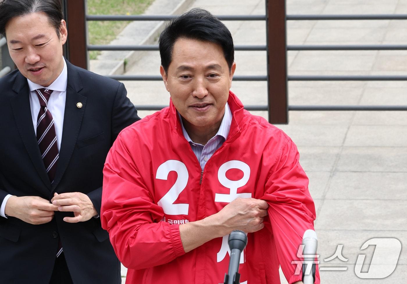 본문 이미지 - 6.3 지방선거 서울시장 예비후보자 등록을 마친 오세훈 국민의힘 후보가 27일 서울 종로구 보신각 앞에서 기자회견을 앞두고 후보복을 착용하고 있다. 2026.4.27 ⓒ 뉴스1 최지환 기자