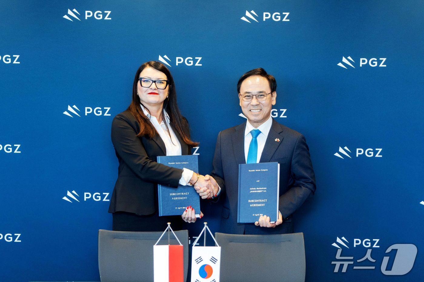 본문 이미지 - 지난 27일(현지 시각) 폴란드 바르샤바에서 열린 K2 전차 K2PL 및 구난전차 현지 생산·정비 협력 계약식에서 이용배 현대로템 사장(오른쪽), 모니카 크루첵 부마르 사장(왼쪽) 등 관계자들이 기념촬영을 하고 있다(현대로템 제공). 2026.4.27.