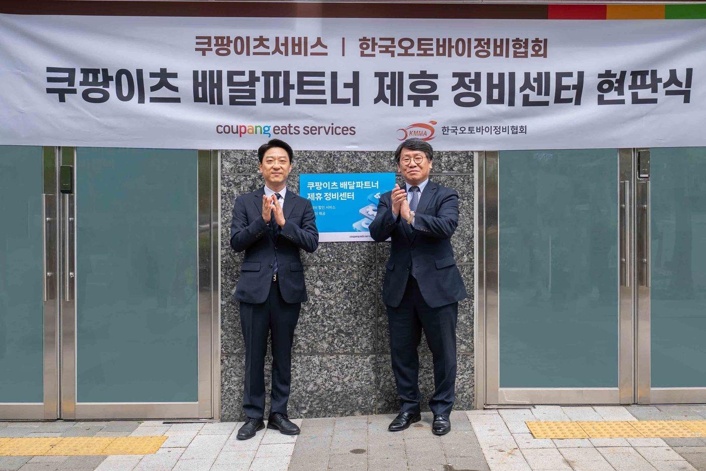 본문 이미지 - 강동진 쿠팡이츠서비스 상무(왼쪽)와 이형석 한국오토바이정비협회 회장이 28일 서울 마포구 소재 쿠팡이츠서비스 제휴 정비센터에서 현판식을 기념하고 있다.(쿠팡 제공)